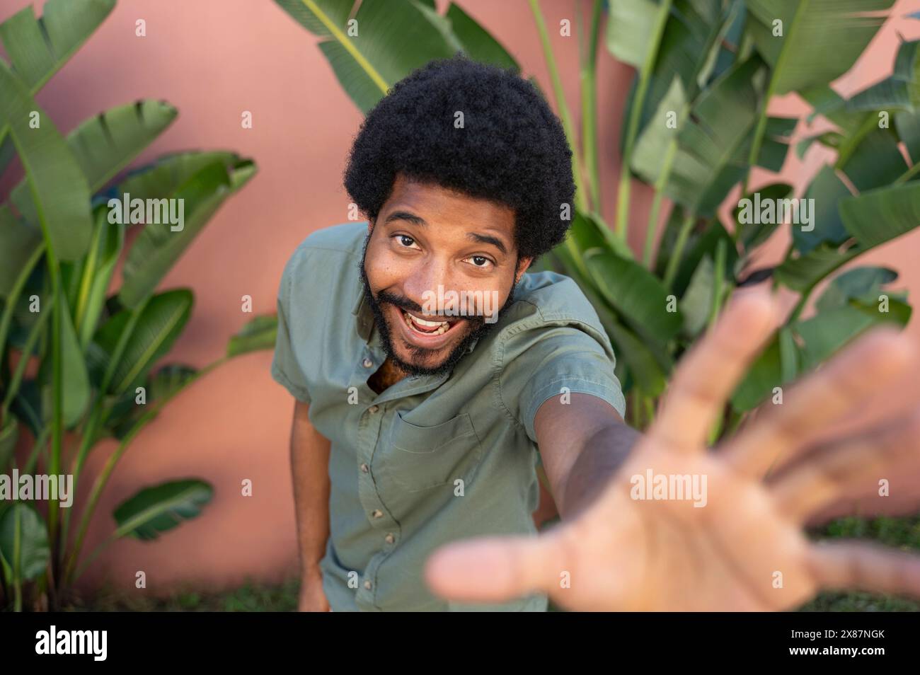 Uomo afro sorridente che gestiva vicino alle palme Foto Stock