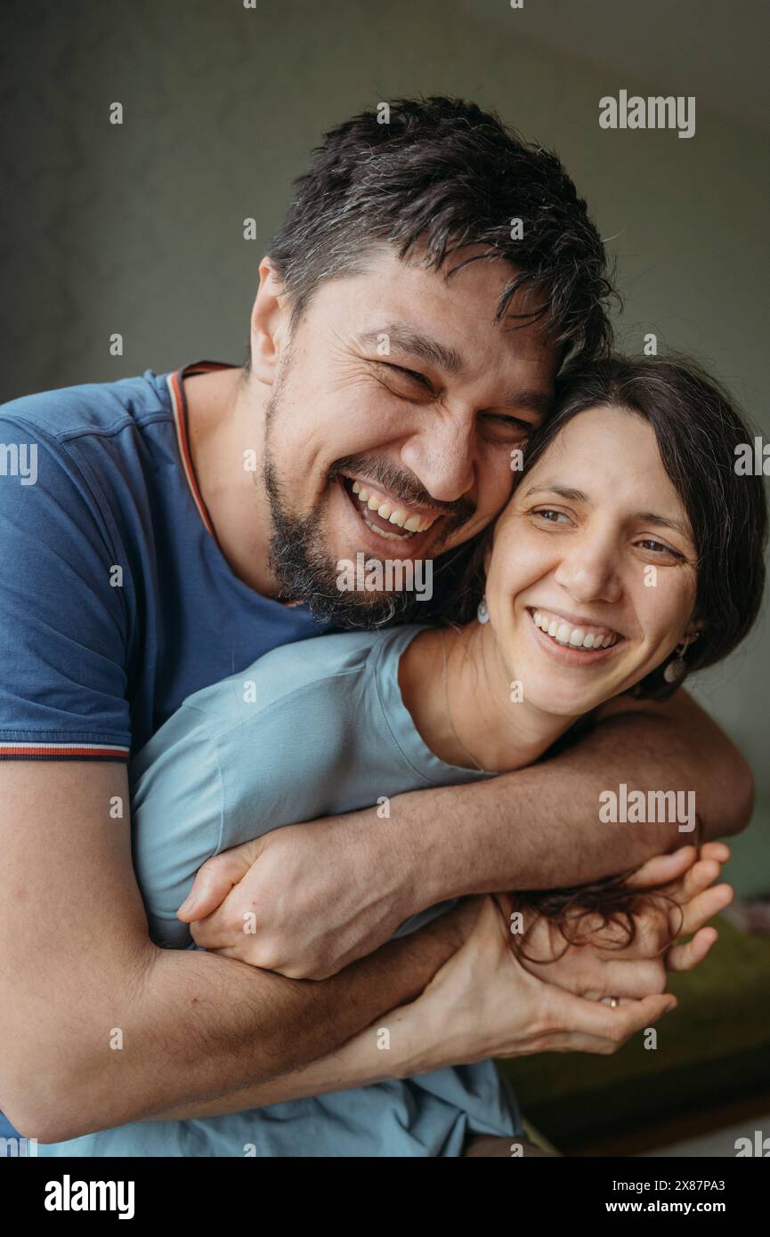 Un uomo felice che abbraccia una donna a casa Foto Stock
