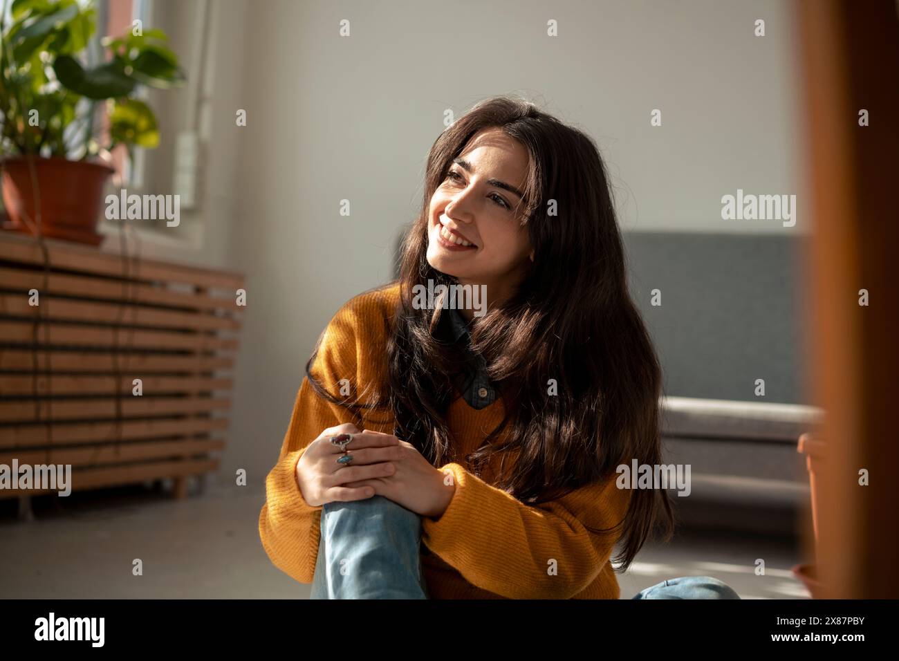 Giorno donna sorridente che sogna a casa Foto Stock