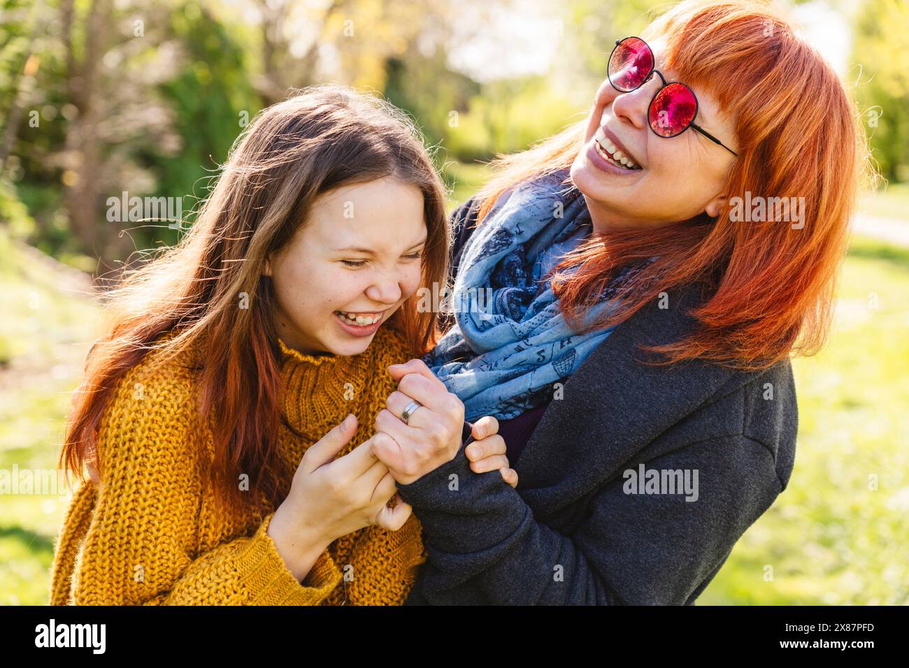 Madre e figlia felici che ridono nella giornata di sole al parco Foto Stock