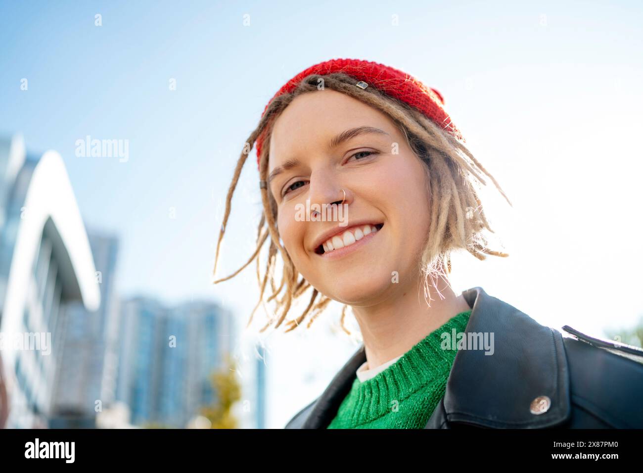 Giovane donna sorridente con lochi e anello per il naso Foto Stock