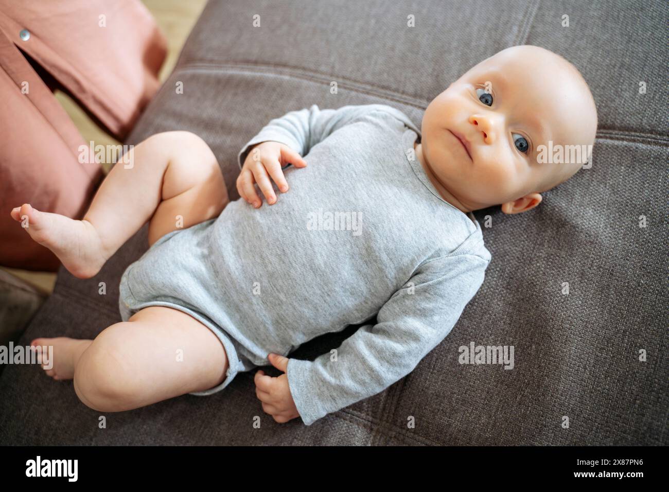 Bambino sdraiato sul divano di casa Foto Stock