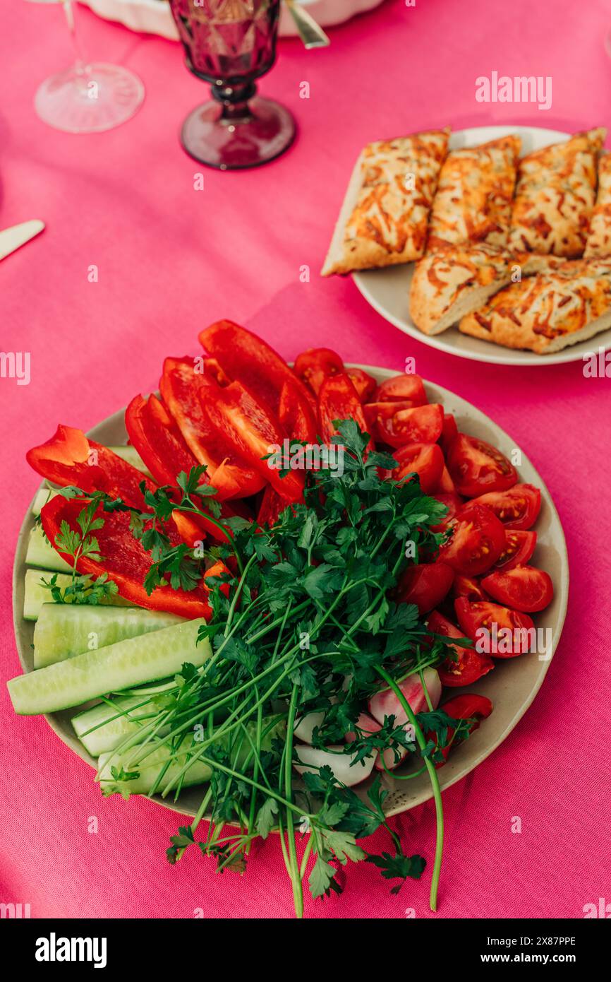 Piatto di verdure varie vicino al pane ripieno sul tavolo da pranzo Foto Stock