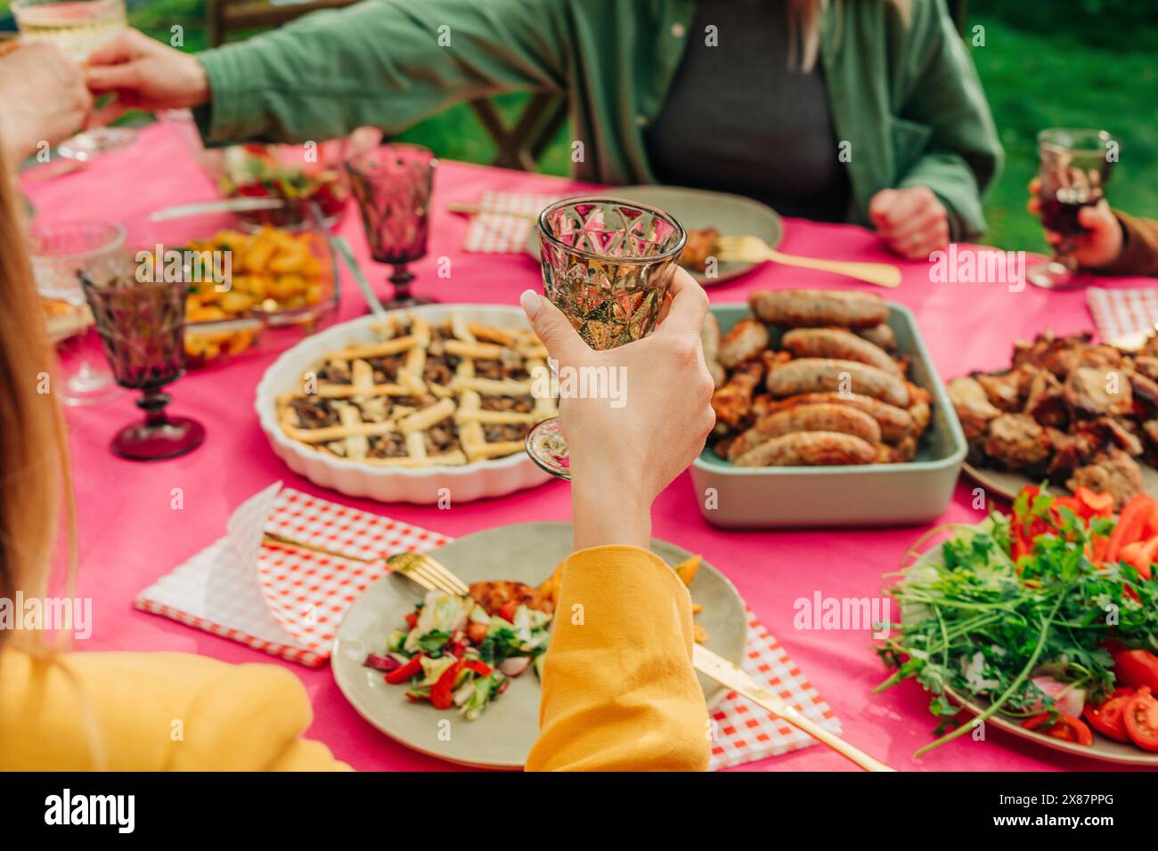 Le famiglie possono gustare cibo e brindare a tavola Foto Stock