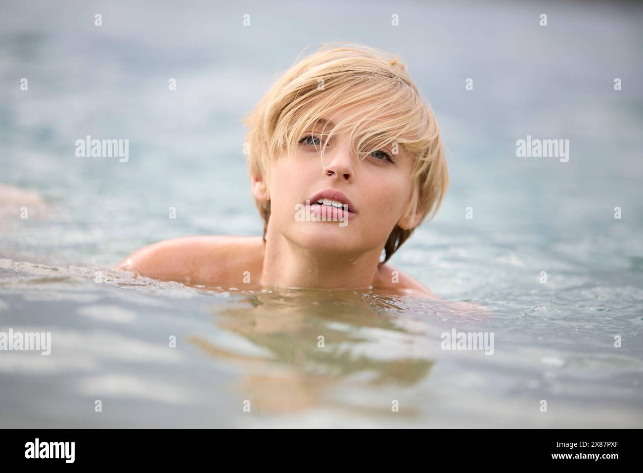 Bella giovane donna bionda che nuota nel lago Foto Stock