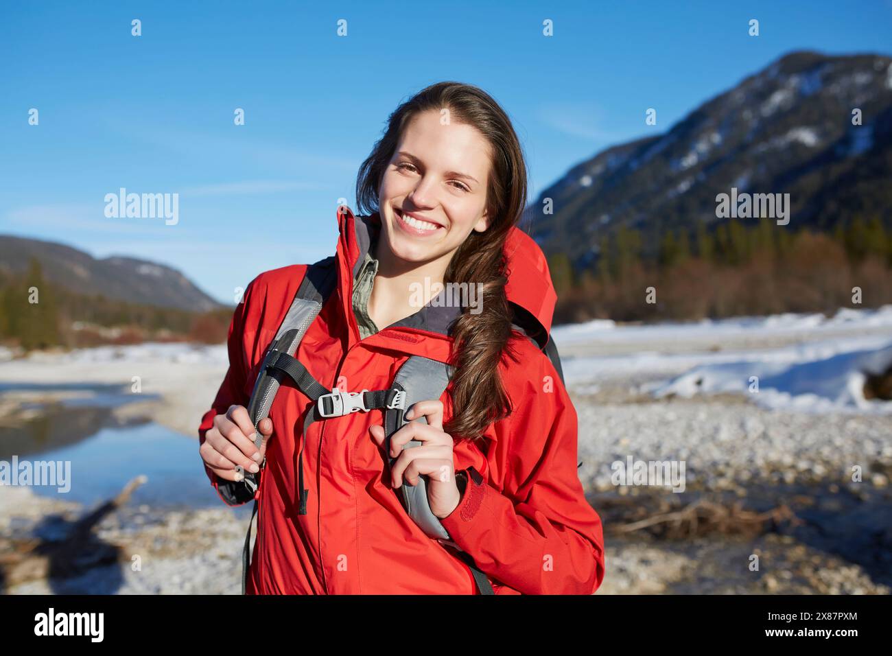 Giovane donna felice che fa trekking sulle montagne sotto il cielo Foto Stock