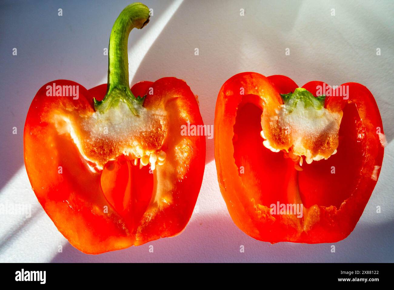 Un peperone rosso tagliato in due. Foto Stock