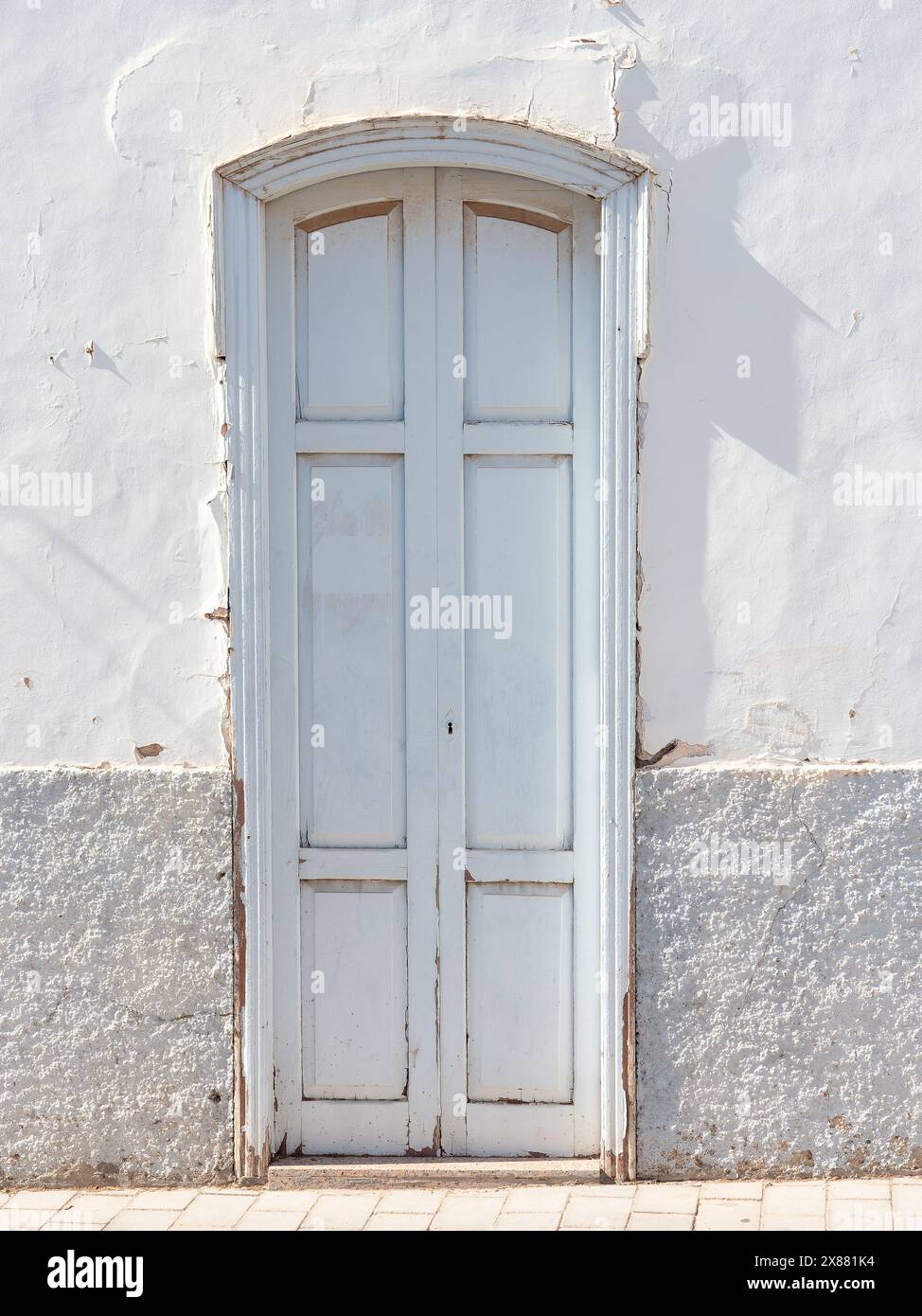 Vecchia porta di legno dipinta di bianco sulla facciata d'ingresso di una casa Foto Stock