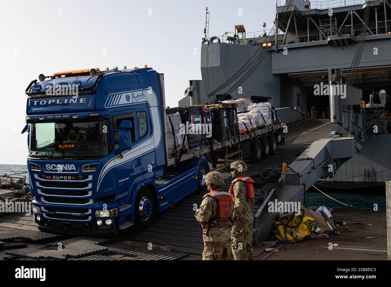 Mar Mediterraneo, Israele. 18 maggio 2024. I soldati dell'esercito degli Stati Uniti assegnati alla 7th Transportation Expeditionary Brigade, dirigono il trasferimento di aiuti umanitari dal MV Roy P. Benavidez alla Roll-on Roll-off Distribution Facility del Trident Floating Pier, 18 maggio 2024, a Gaza, in territorio palestinese. Il molo galleggiante sarà utilizzato per spostare gli aiuti umanitari direttamente dalle navi alla terraferma per il popolo palestinese a Gaza. Credito: SSgt. Malcolm Cohens-Ashley/US Army Photo/Alamy Live News Foto Stock