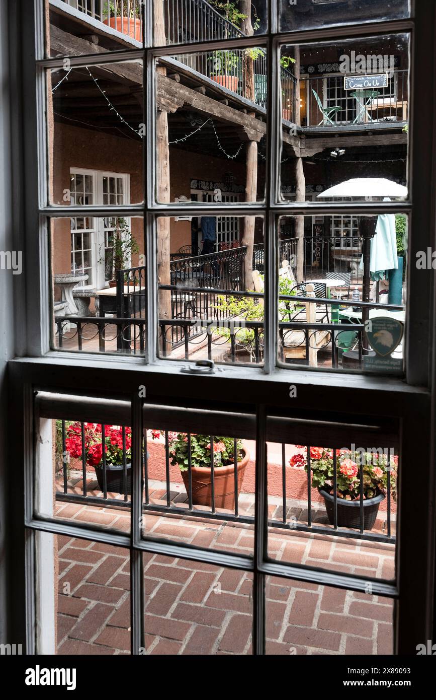 Vista dalla finestra di un complesso multipiano che ospita aziende e caffè con posti a sedere all'aperto e vasi di fiori a Las Cruces, NEW MEXICO Foto Stock