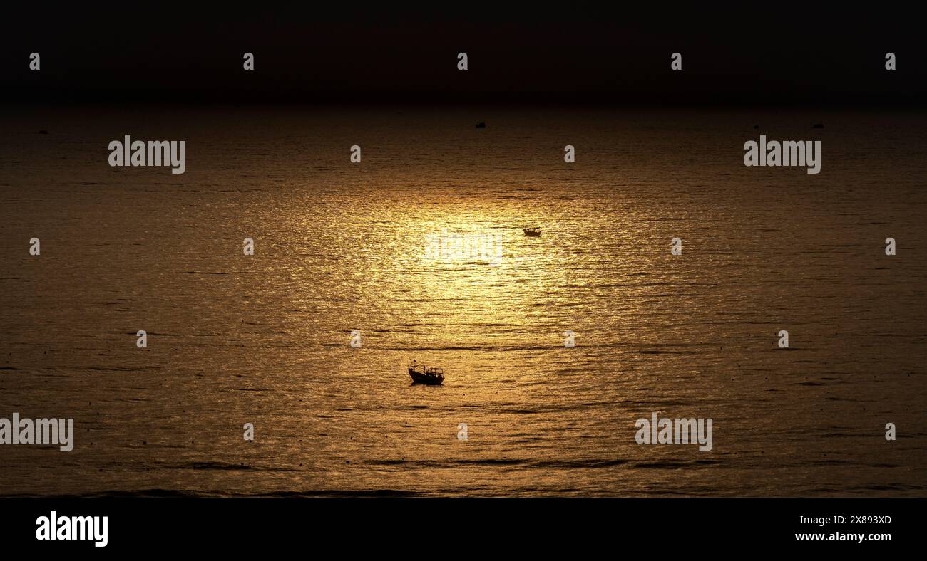 Piccola barca nel mare all'alba Foto Stock