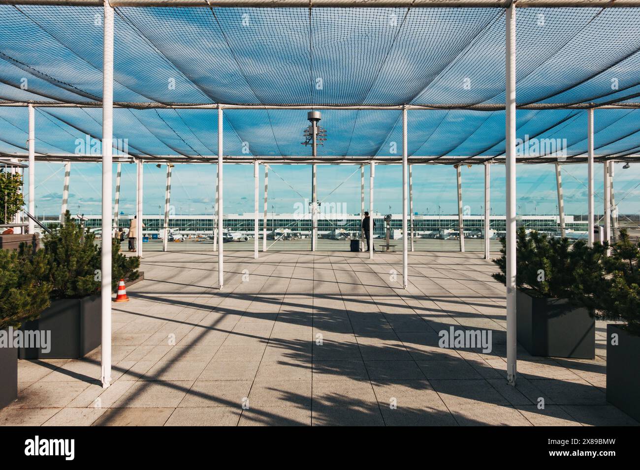 Un soffitto a rete sopra la piattaforma di osservazione esterna del Terminal 2 dell'Aeroporto Internazionale di Monaco, in un soleggiato pomeriggio autunnale Foto Stock