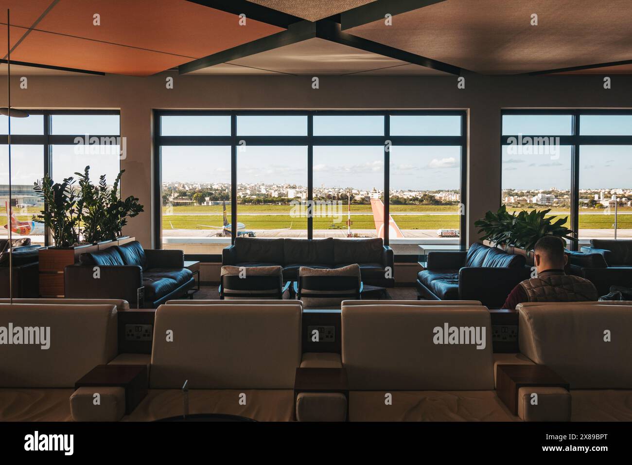 La Valette Club Lounge presso l'Aeroporto Internazionale di Malta, presenta interni moderni con vista panoramica sulla pista, elementi di design in legno Foto Stock