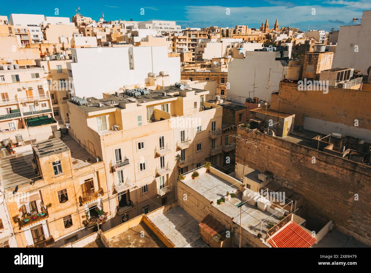 Gli appartamenti residenziali con una tavolozza di colori della costa sabbiosa spargono lo skyline della città di Sliema, Malta Foto Stock