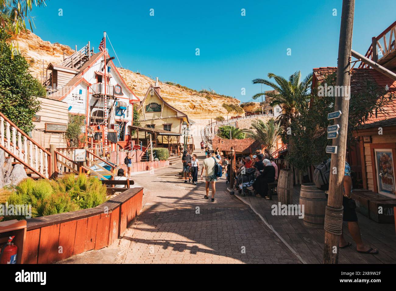 Turisti che visitano il Popeye Village, un set cinematografico degli anni '1980 costruito sulle rive di Anchor Bay, Malta. Ora una delle principali attrazioni turistiche Foto Stock