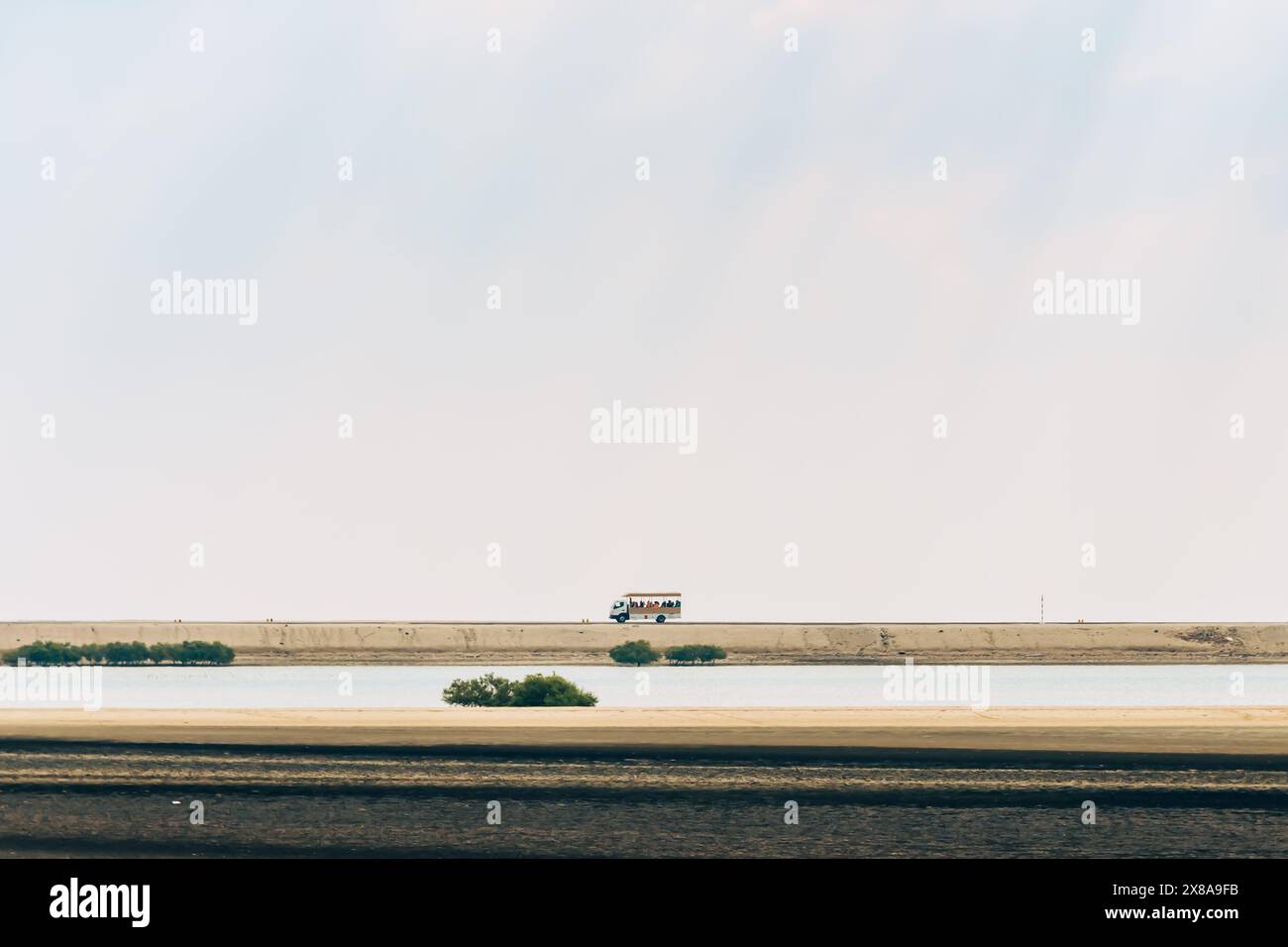 Un autobus solitario attraversa un paesaggio aperto, simboleggiando la solitudine e il viaggio che ti attende. Foto Stock