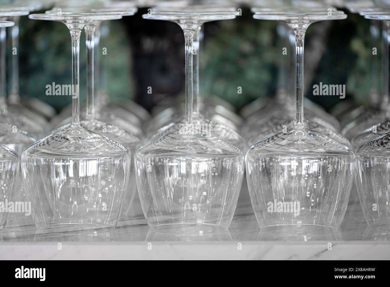 I bicchieri da vino sono disposti capovolti sul banco di marmo del bar Foto Stock