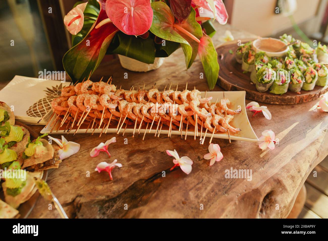 Spettacolo di antipasti ai gamberi tropicali con involtini primaverili e orchidee Foto Stock