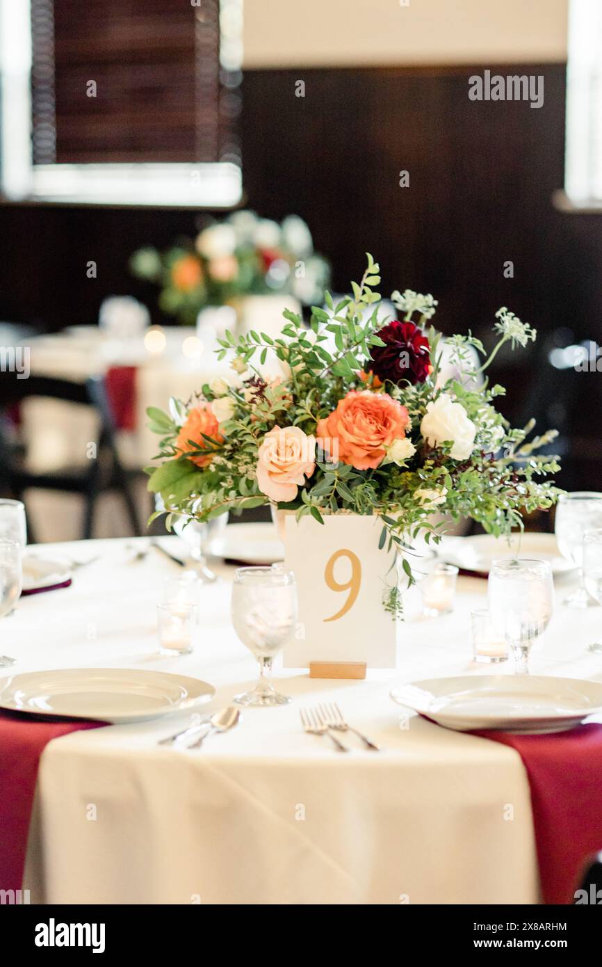 Elegante disposizione del tavolo con centrotavola floreale e numero del tavolo Foto Stock