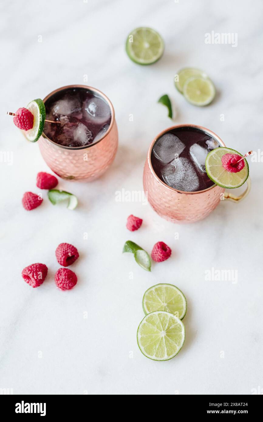 Due cocktail in tazze di rame con lime e lampone Foto Stock