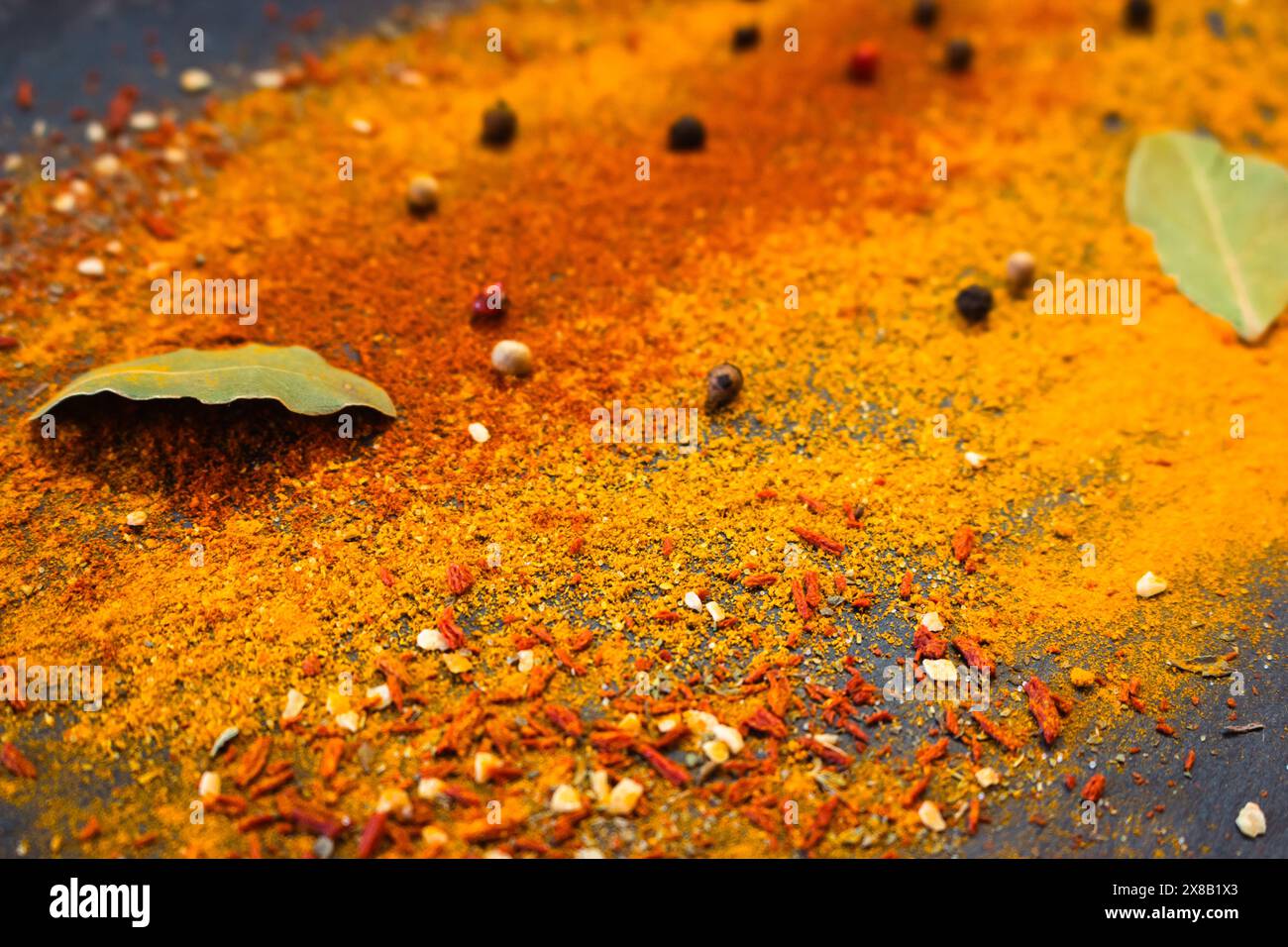 Spezie indiane su sfondo nero. Curry e peperoncino in polvere, pepe, paprika e foglie di alloro. Cultura indiana. Cucina asiatica. Erbe piccanti. Foto Stock