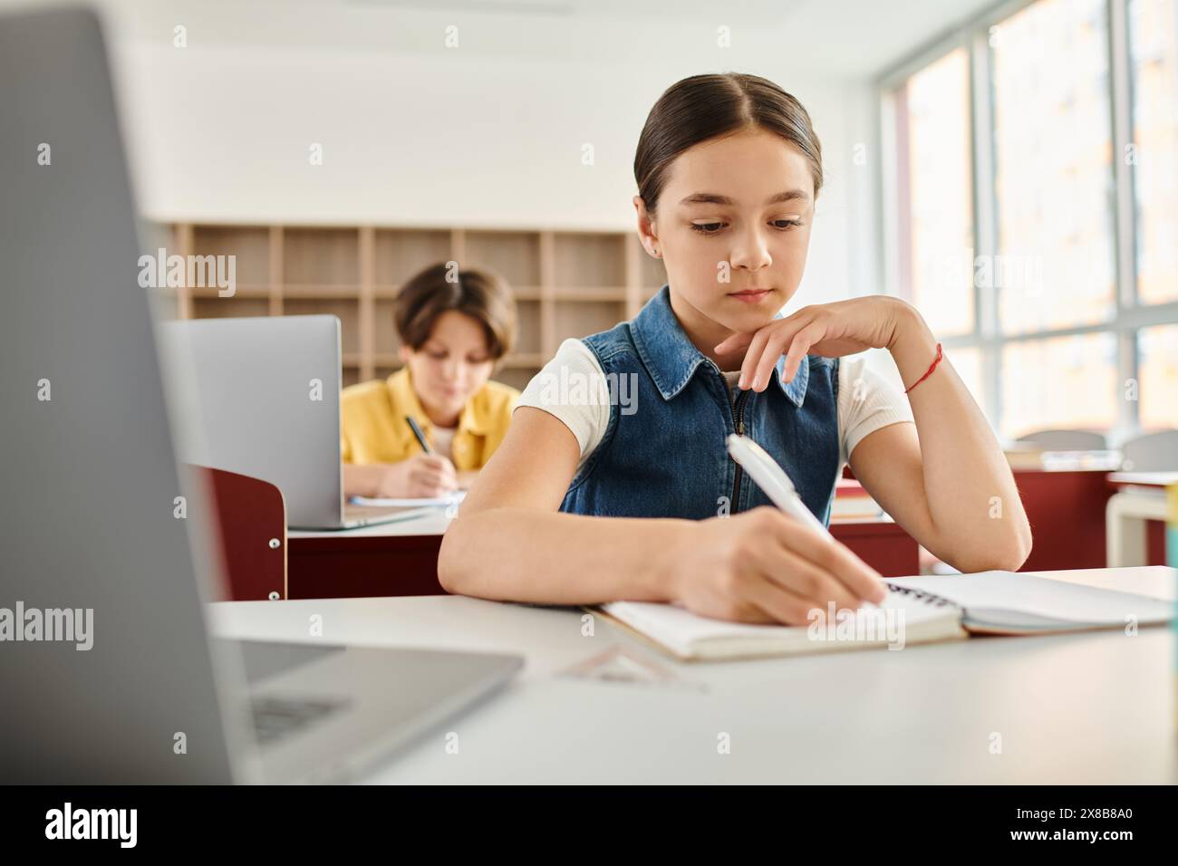 gli studenti attenti prendono appunti diligentemente mentre imparano in una vivace classe. Foto Stock