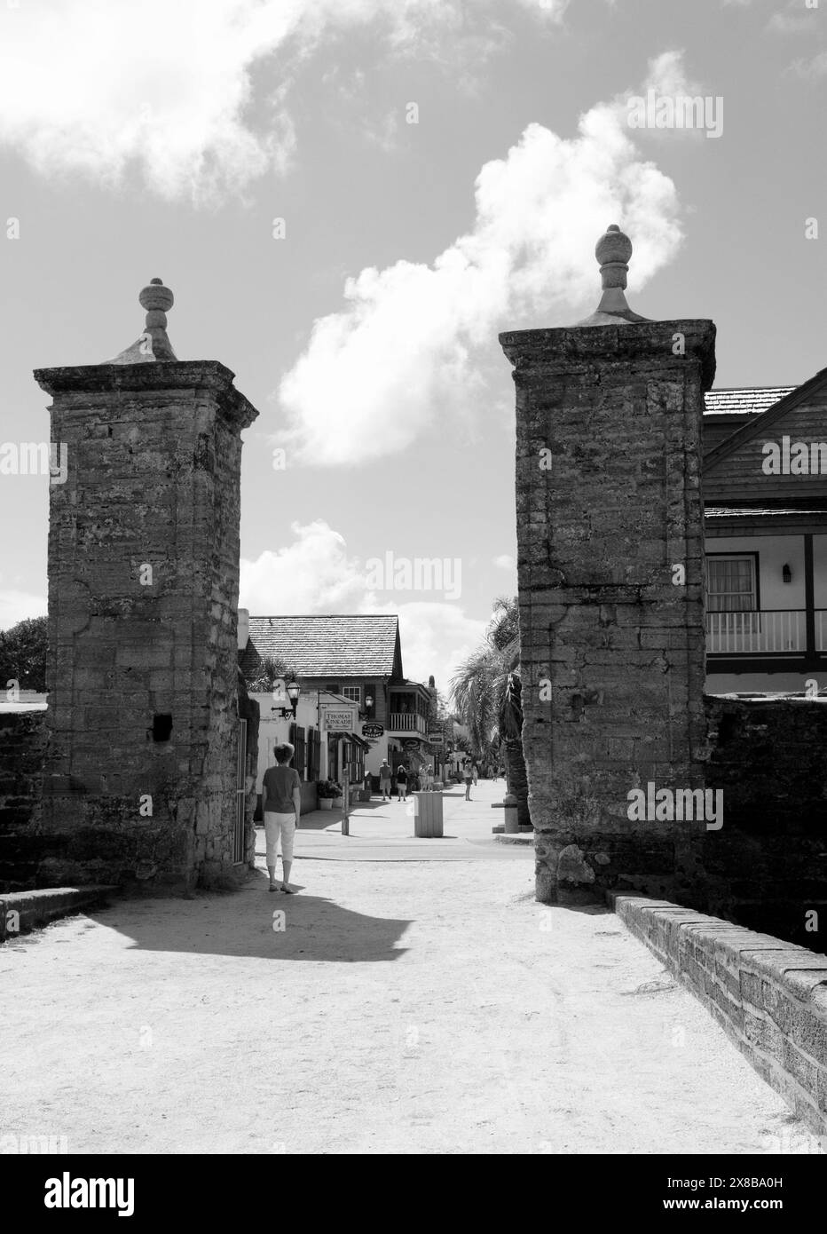 Una donna che cammina attraverso le storiche porte cittadine di St. Augustine, Florida, Stati Uniti. Foto Stock