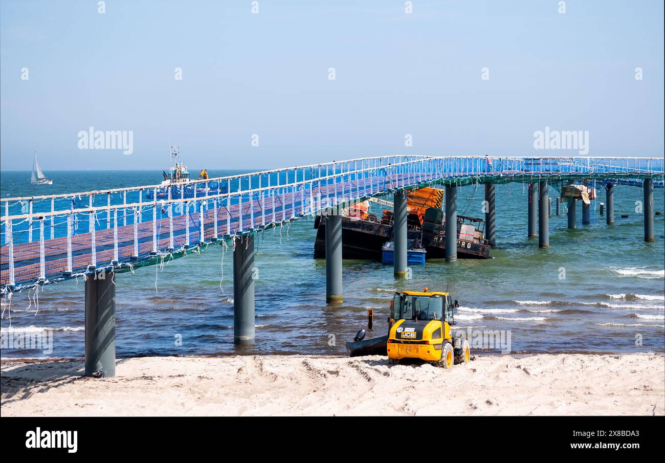 Timmendorfer Strand, Germania. 24 maggio 2024. Un pontone che è stato strappato si trova nel Mar Baltico a Timmendorfer Strand sul molo. I lavori hanno iniziato a recuperare la piattaforma di lavoro a cuneo, che si era rotta in forti onde. Credito: Daniel Bockwoldt/dpa/Alamy Live News Foto Stock