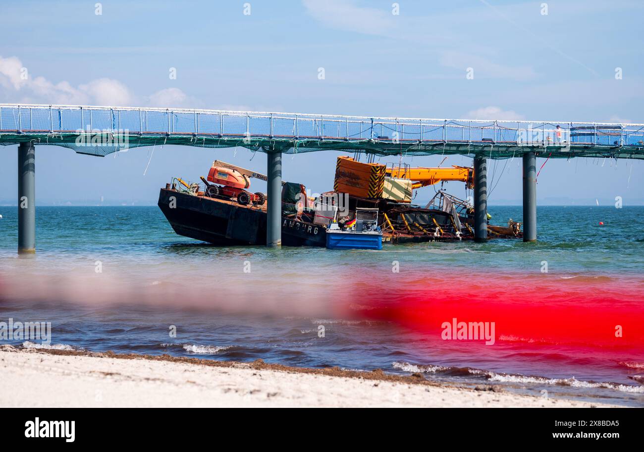 Timmendorfer Strand, Germania. 24 maggio 2024. Nel Mar Baltico, sul molo di Timmendorfer Strand, sorge un pontile che è stato strappato. Il recupero della piattaforma di lavoro a cuneo, che si era rotta in forti onde, è iniziato. Credito: Daniel Bockwoldt/dpa/Alamy Live News Foto Stock