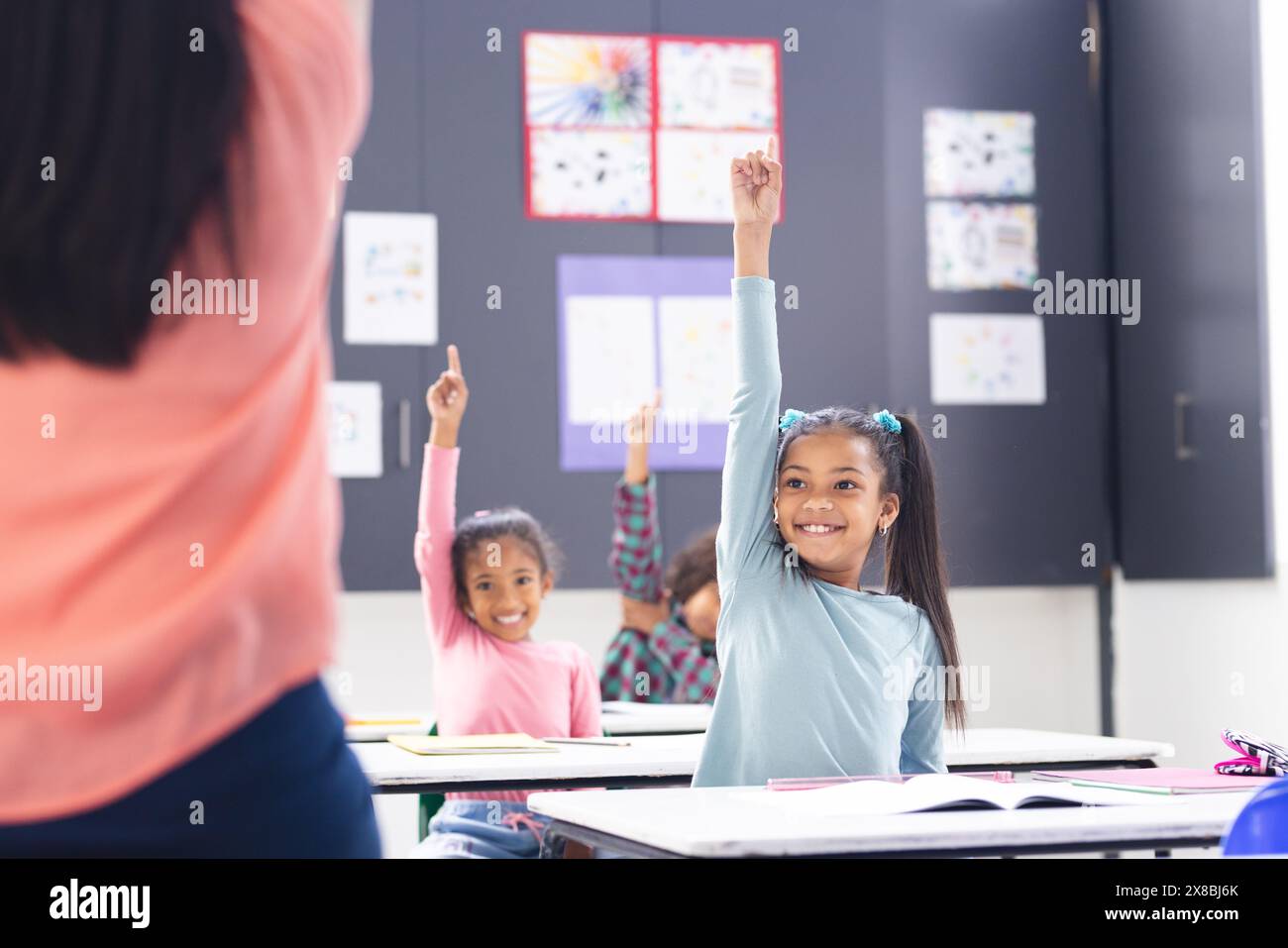 A scuola, la giovane insegnante birazziale si trova di fronte alla sua diversa classe in classe Foto Stock