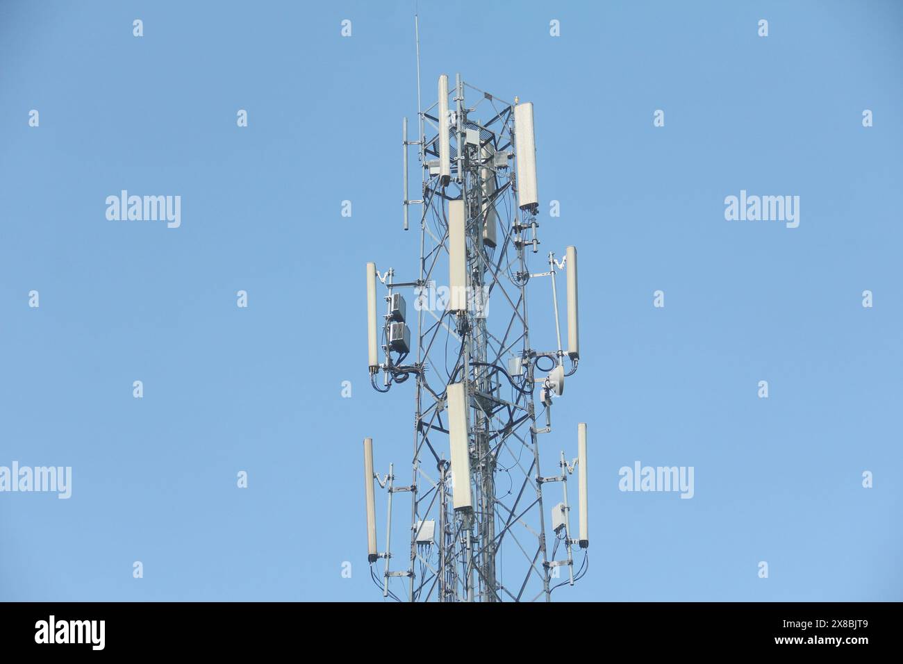 Torre delle telecomunicazioni alta su uno sfondo blu brillante Foto Stock