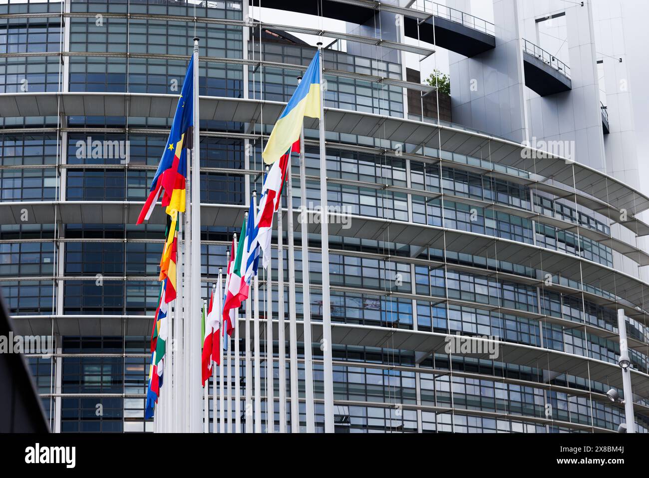 24 maggio 2024, Francia, Straßburg: Le bandiere dell'Unione europea, dei suoi stati membri e dell'Ucraina volano di fronte all'edificio del Parlamento europeo. Dal 6 al 9 giugno 2024, i cittadini dei 27 stati membri dell'UE eleggeranno il Parlamento europeo. Foto: Philipp von Ditfurth/dpa Foto Stock