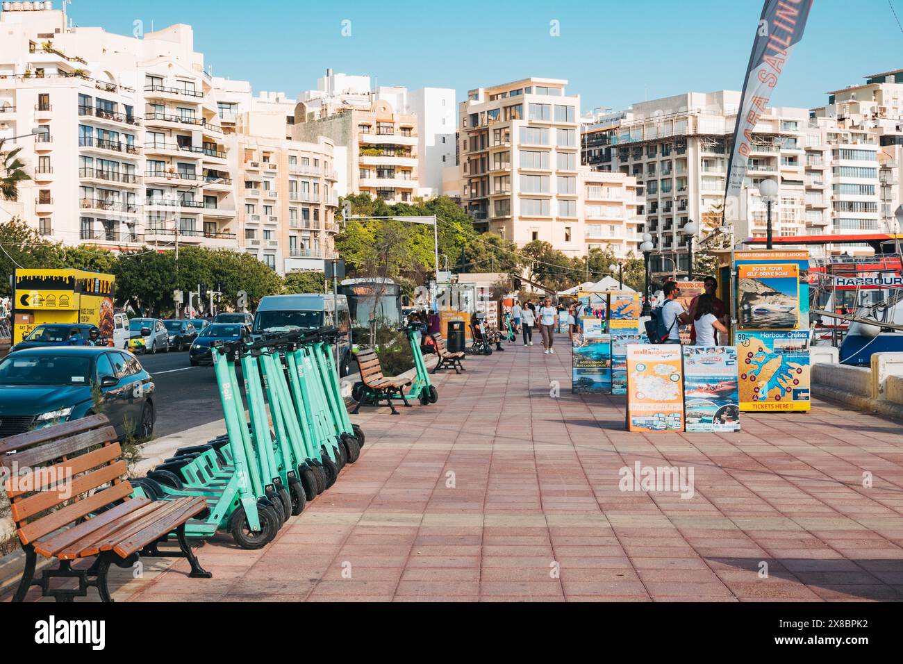 Una fila di e-scooter Bolt appena caricati allineati lungo il marciapiede pronti per l'uso a Sliema, Malta Foto Stock