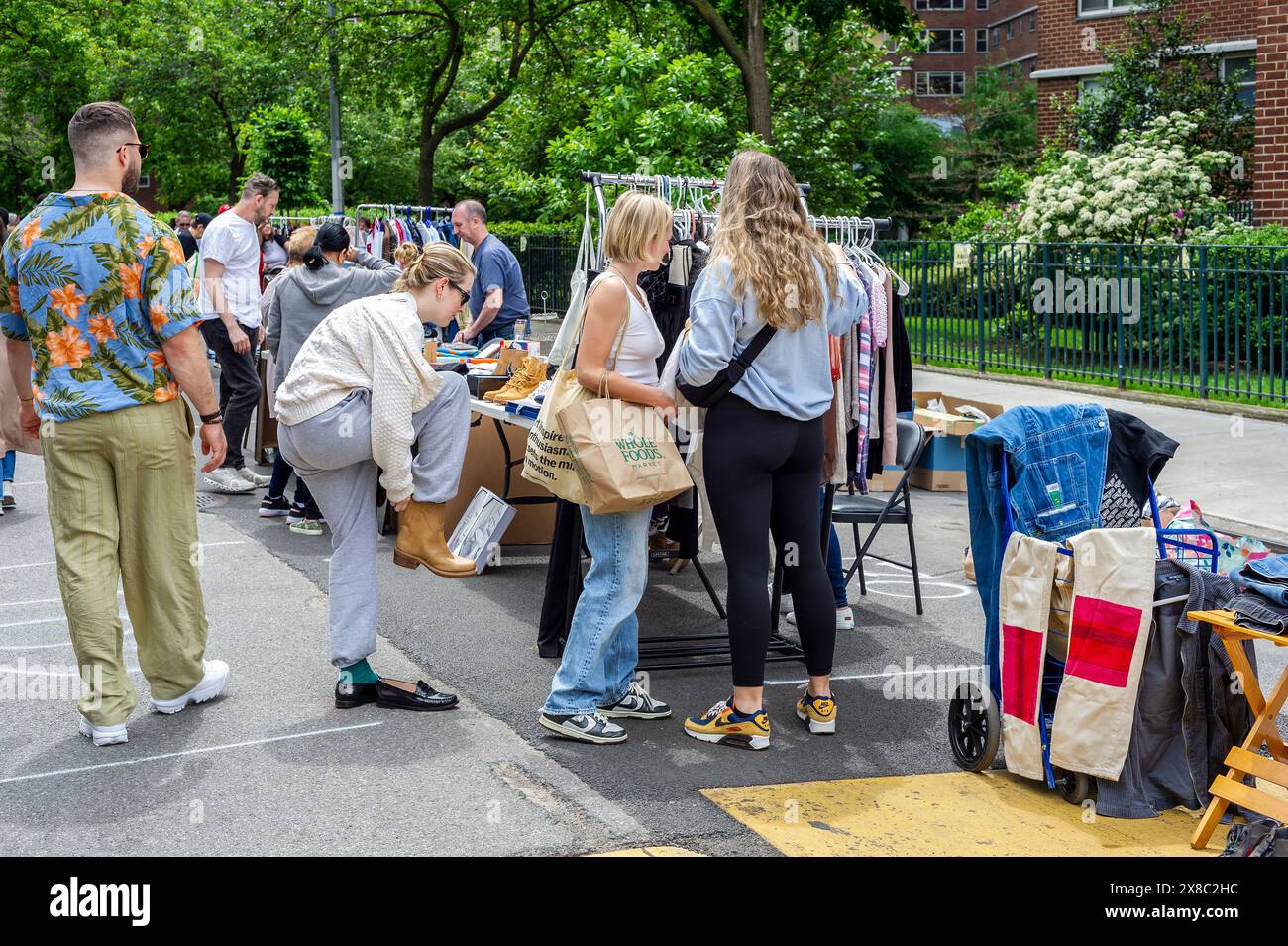 Gli amanti dello shopping cercano occasioni presso l'annuale mercato delle pulci Penn South, nel quartiere di Chelsea, New York, sabato 18 maggio 2024. Il mercato delle pulci appare come Brigadoon, solo una volta all'anno, e i residenti della cooperativa Penn South di 20 edifici hanno uno stravagante servizio di pulizia dell'armadio. Gli amanti dello shopping provenienti da tutta la città vengono al mercato delle pulci che attrae migliaia di visitatori. (© Richard B. Levine) Foto Stock