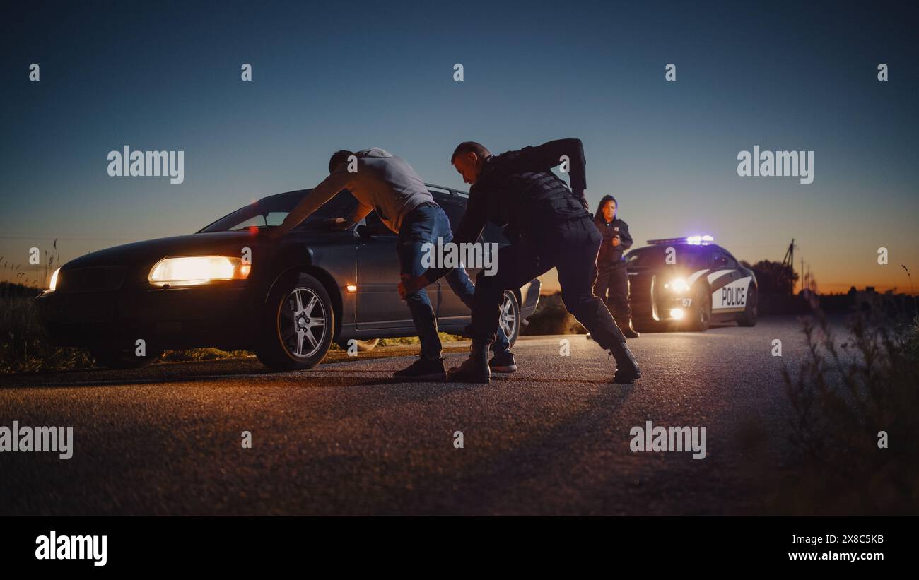 Un poliziotto professionista di mezza età che esegue una ricerca Pat-Down su un Fellon con le mani su Car Hood. Un documentario di procedura per arrestare i sospettati. Poliziotto esperto in cerca di armi Foto Stock