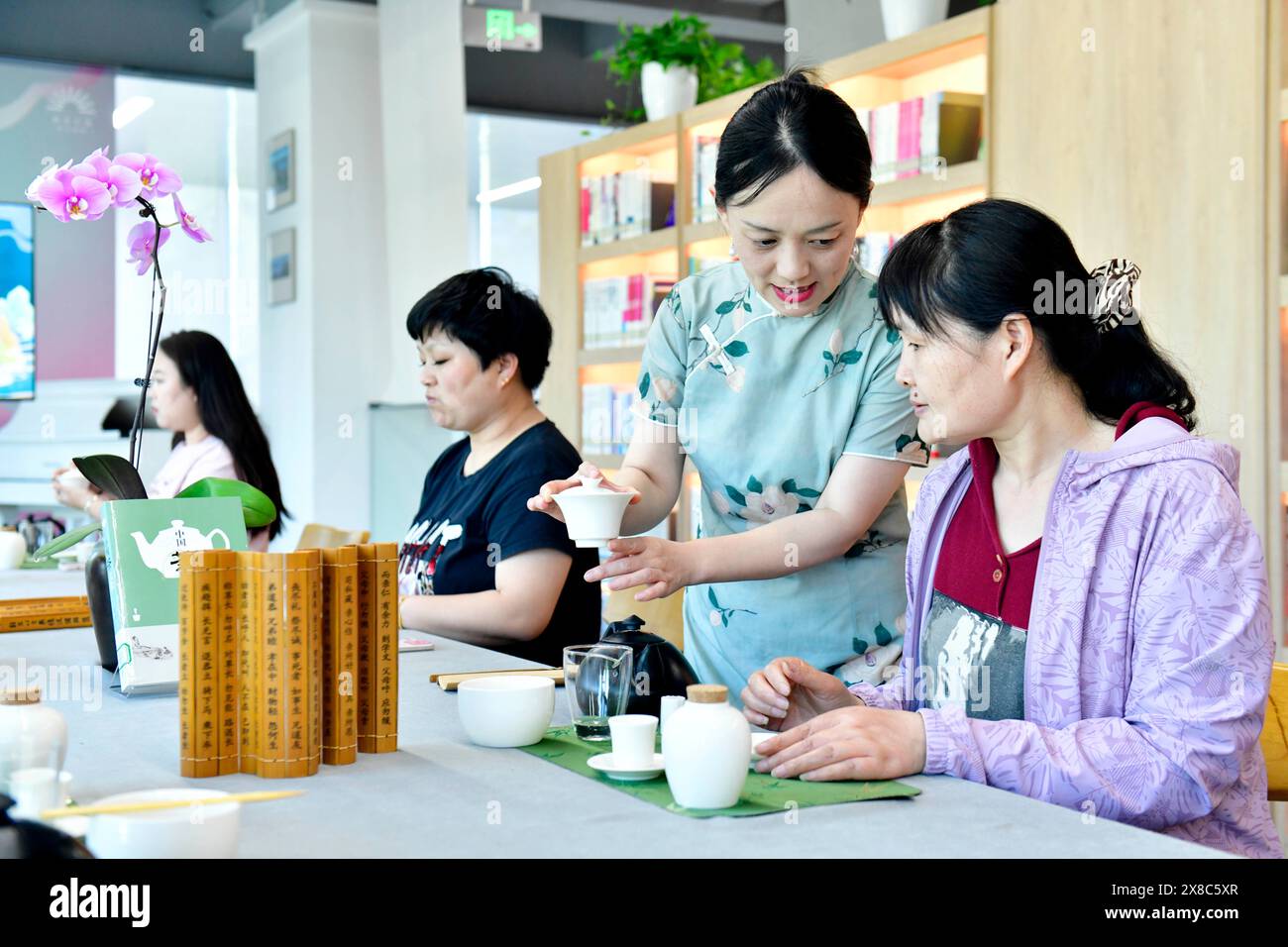 Rizhao, la provincia cinese di Shandong. 23 maggio 2024. I cittadini imparano a conoscere l'arte del tè in una sala di lettura urbana nel distretto di Donggang di Rizhao, nella provincia di Shandong della Cina orientale, 23 maggio 2024. Diciannove sale di lettura urbane sono state istituite nel distretto di Donggang dal 2020, aperte al pubblico gratuitamente. Nelle sale di lettura si svolgono regolarmente attività speciali, tra cui saloni di lettura, esperienza di patrimoni culturali immateriali e esposizione di prodotti culturali e creativi. Crediti: Meng Tao/Xinhua/Alamy Live News Foto Stock