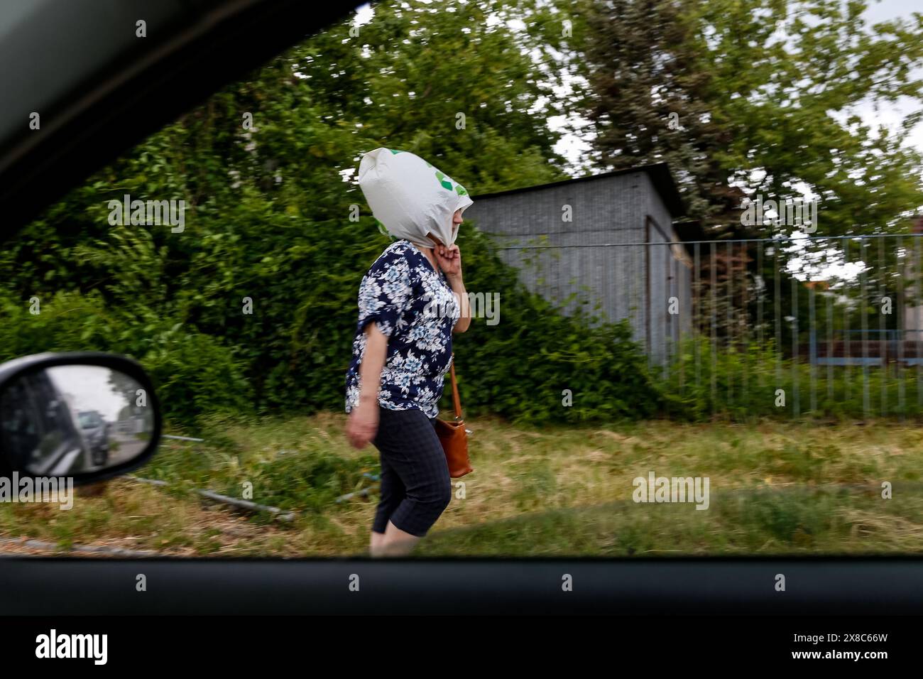 Cracovia, Polonia, 24 maggio 2024. Una donna cammina con un sacchetto di plastica sulla testa mentre una tempesta con venti forti e la grandine passava attraverso Cracovia. Crediti: Dominika Zarzycka/Alamy Live News. Foto Stock