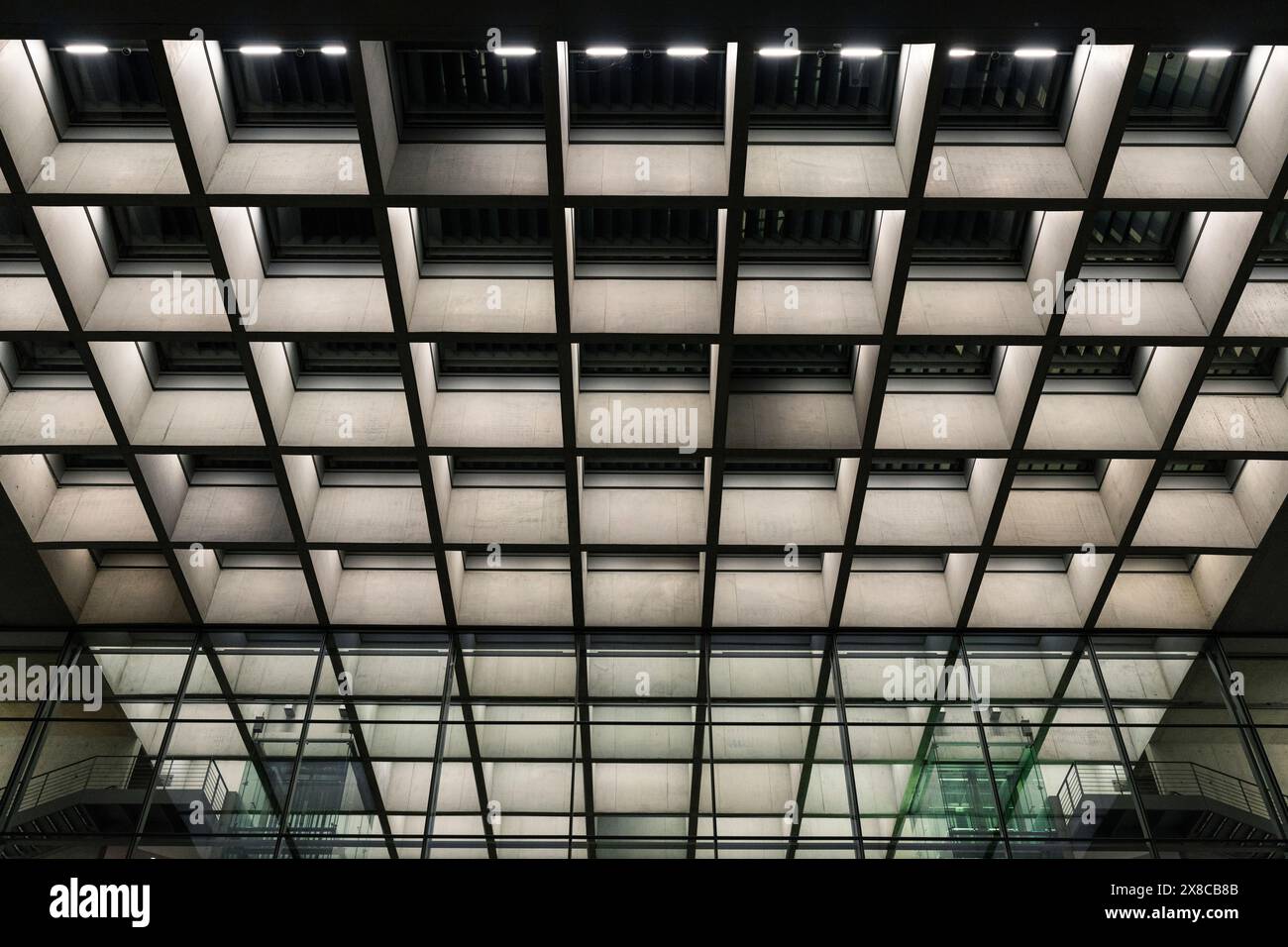 Illuminazione moderna simmetrica e design a soffitto di un edificio per uffici Foto Stock