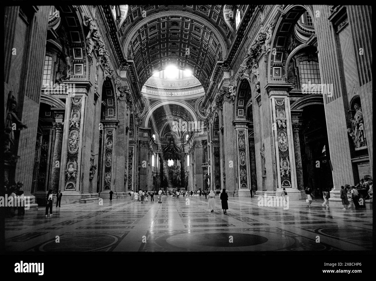 Interno della Basilica di San Pietro, città del Vaticano, Roma Italia 1990 la Basilica Papale di San Pietro in Vaticano (in italiano: Basilica Papale di San Pietro in Vaticano), o semplicemente la Basilica di San Pietro (in latino: Basilica Sancti Petri), è una chiesa dell'alto Rinascimento italiano situata nella città del Vaticano, un microstato indipendente enclavaved all'interno della città di Roma. Fu inizialmente progettata nel XV secolo da Papa Nicola V e poi da Papa Giulio II per sostituire l'antica basilica di San Pietro, che fu costruita nel IV secolo dall'imperatore romano Costantino il grande. Costruzione del pr Foto Stock