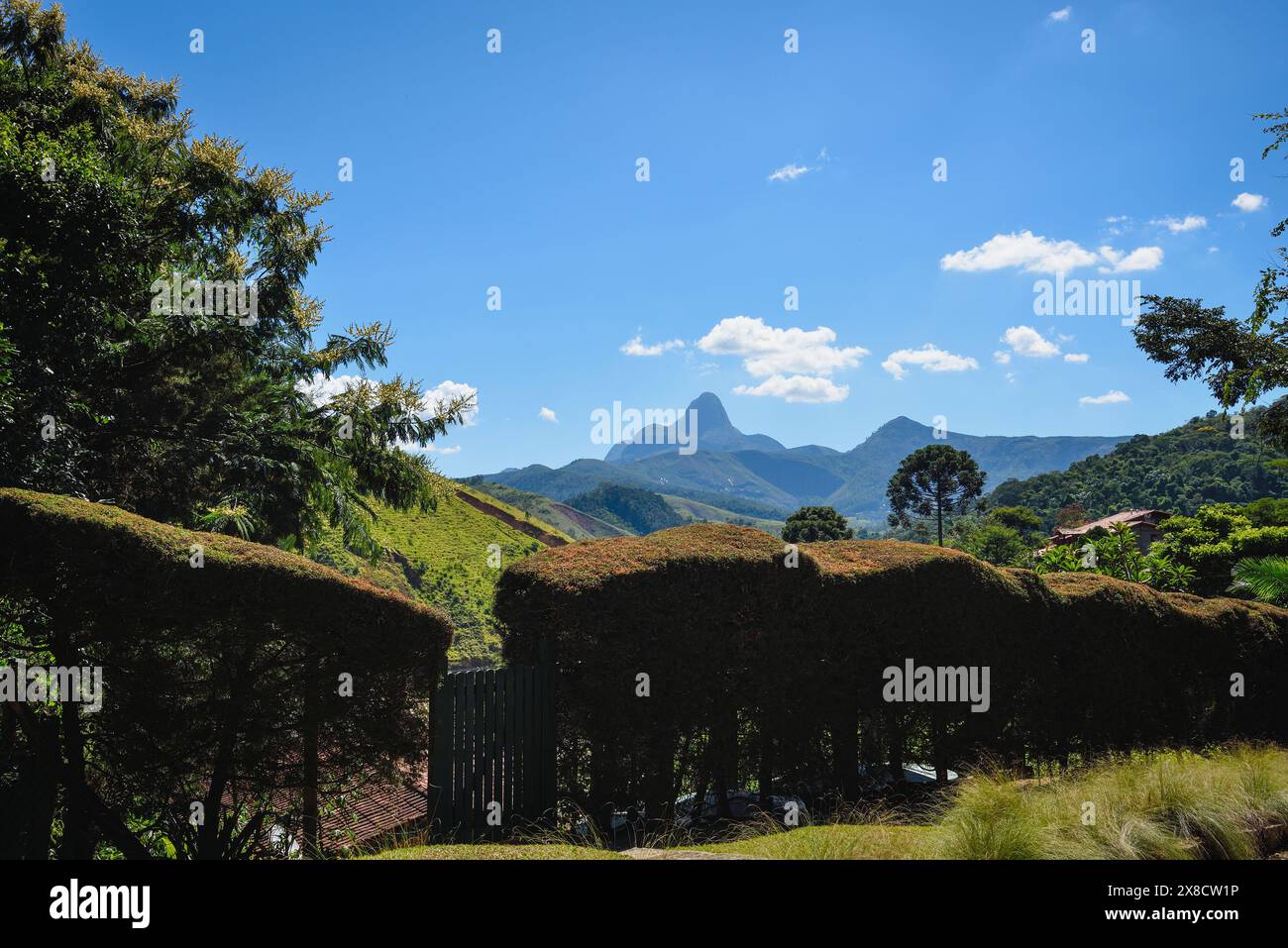 Una vista idilliaca di una siepe e montagne in una splendida giornata nella campagna di Rio de Janeiro, Brasile Foto Stock