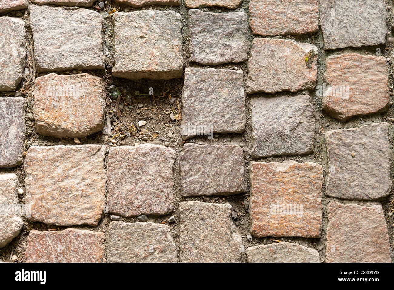 Blocco di pietre di pavimentazione che costruiscono un sentiero, dove manca una pietra, lasciando un vuoto. Concetto di mancanza di una parte importante, ad esempio in azienda o in li Foto Stock