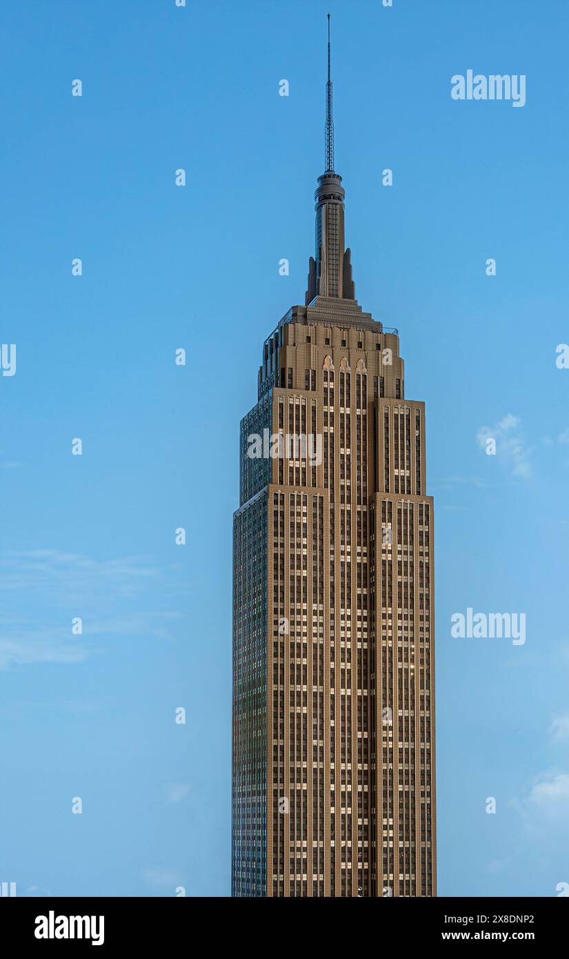 New York, NY, USA - 2 agosto 2023: Cima dell'edificio dell'Empire State contro il cielo blu Foto Stock