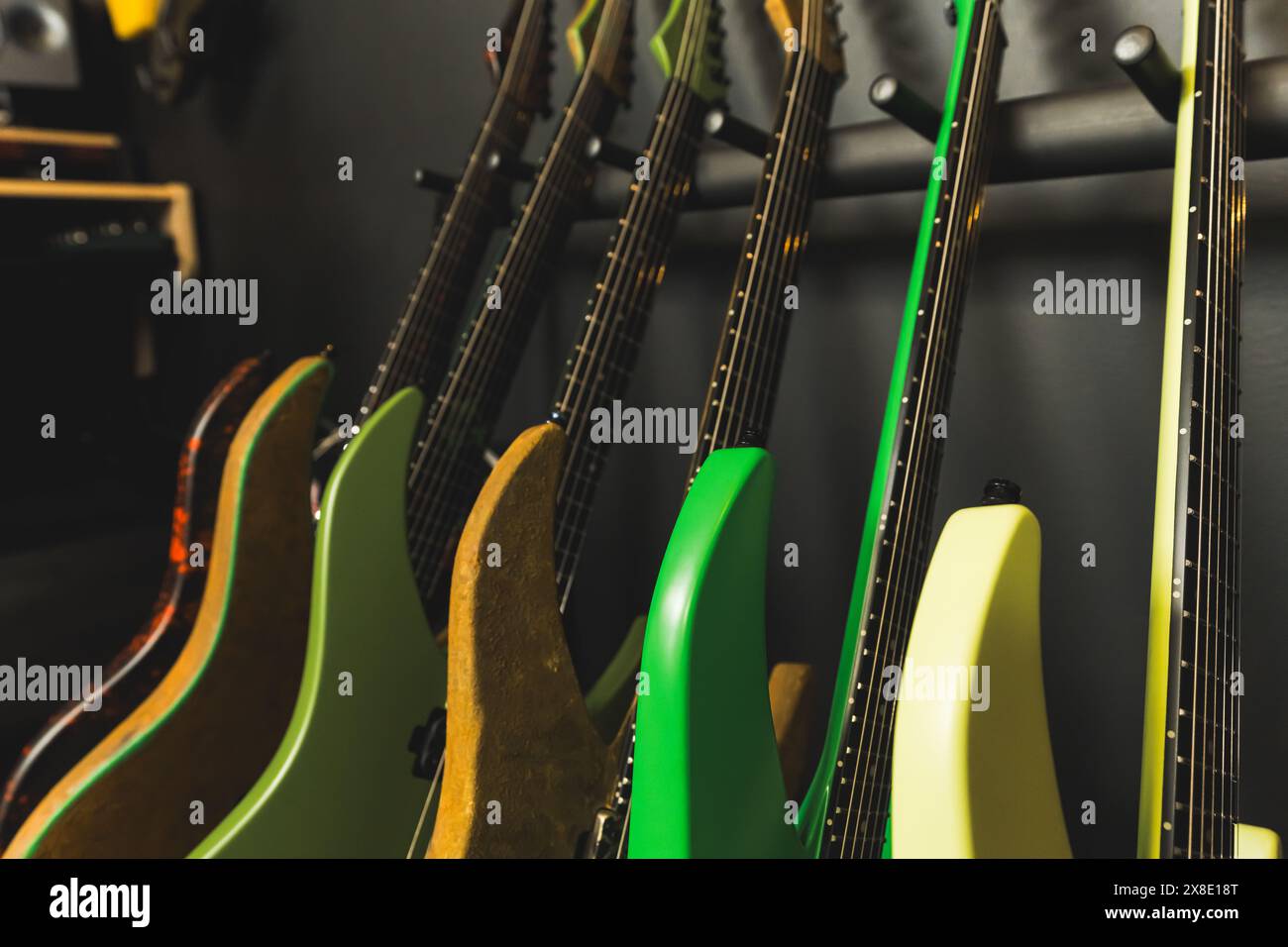 primo piano di colorate chitarre elettriche vicino a un muro nello studio di musica, strumenti moderni, studio di prova. Foto di alta qualità Foto Stock