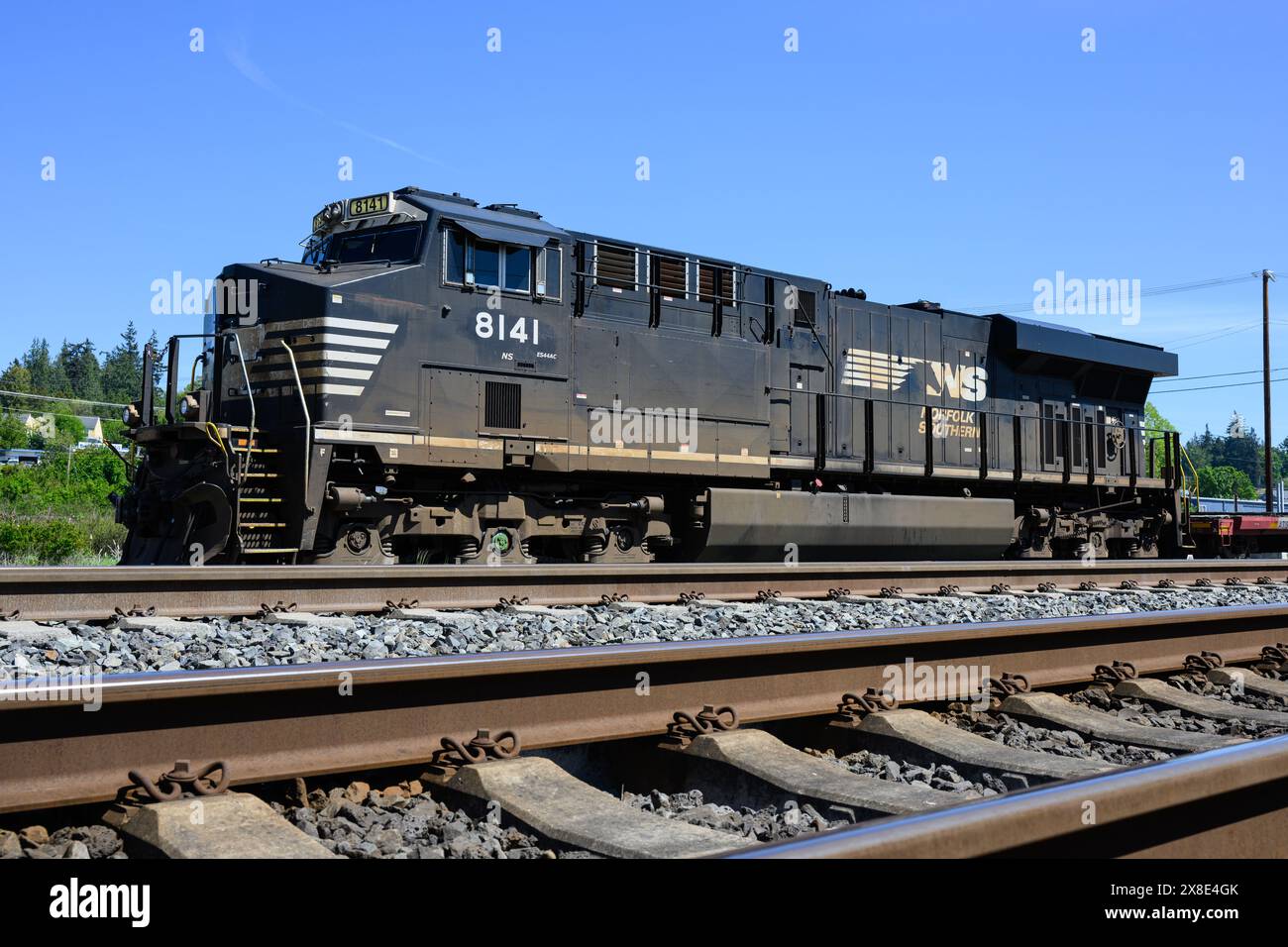Stanwood, WA, USA - 10 maggio 2024; locomotiva merci Norfolk Southern con binario ferroviario e legatura ferroviaria in cemento Foto Stock