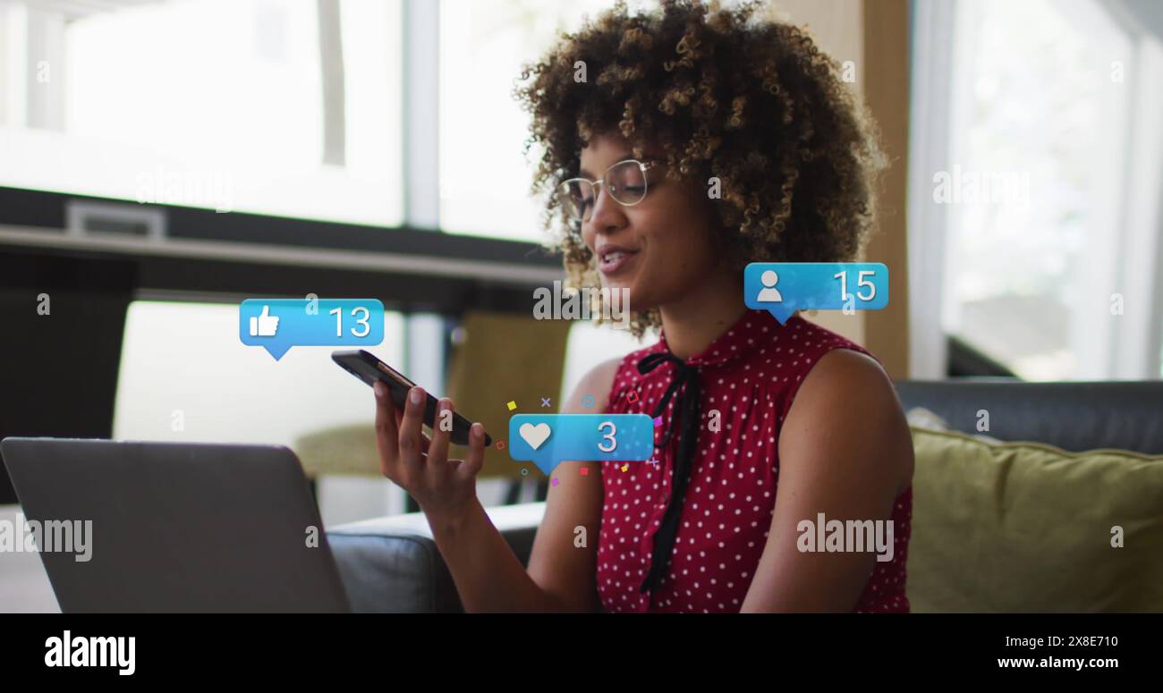 Immagine di icone dei media su una donna afroamericana che usa lo smartphone Foto Stock