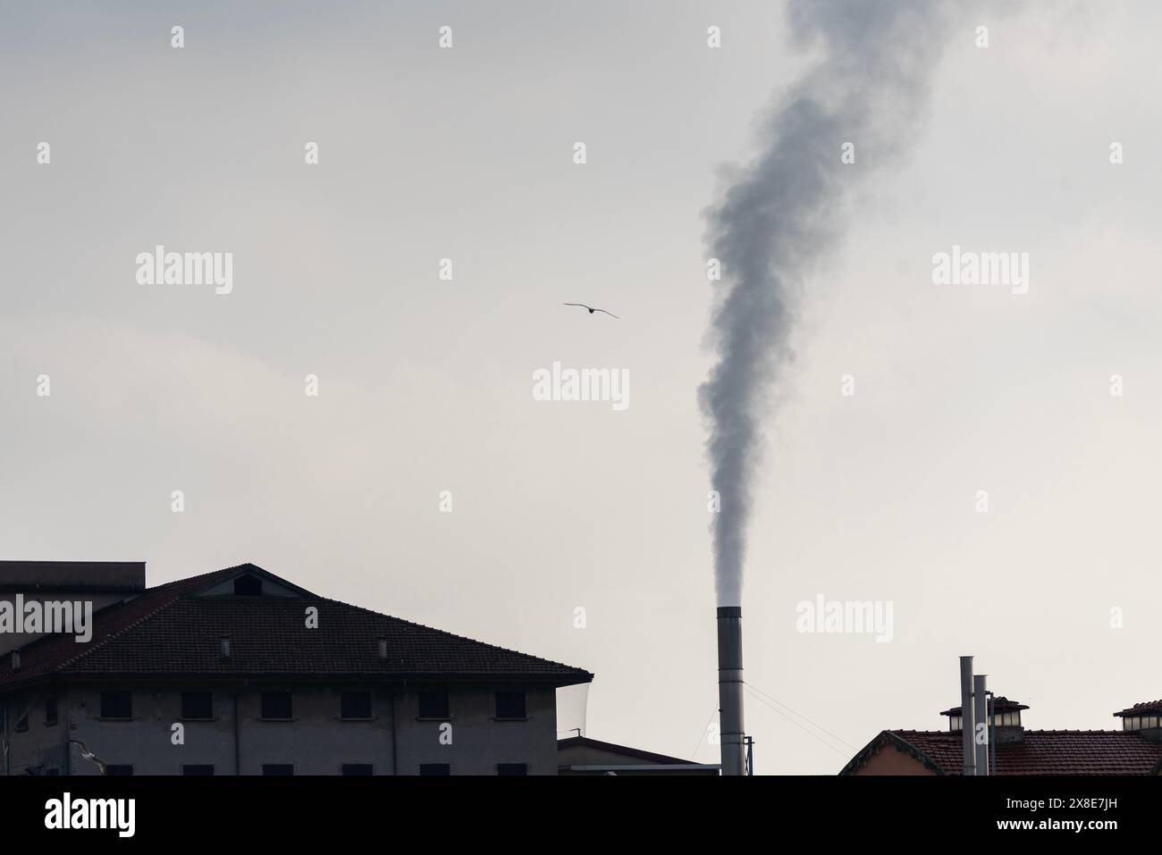 Contesto industriale con camino fumante. Foto Stock