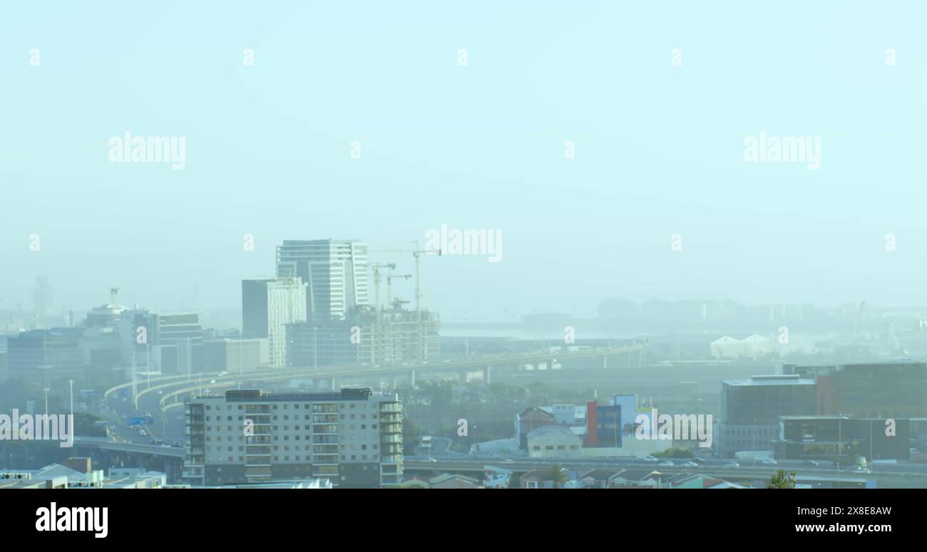 Immagine di un'icona in cerchio su edifici moderni e autostrada contro il cielo limpido Foto Stock