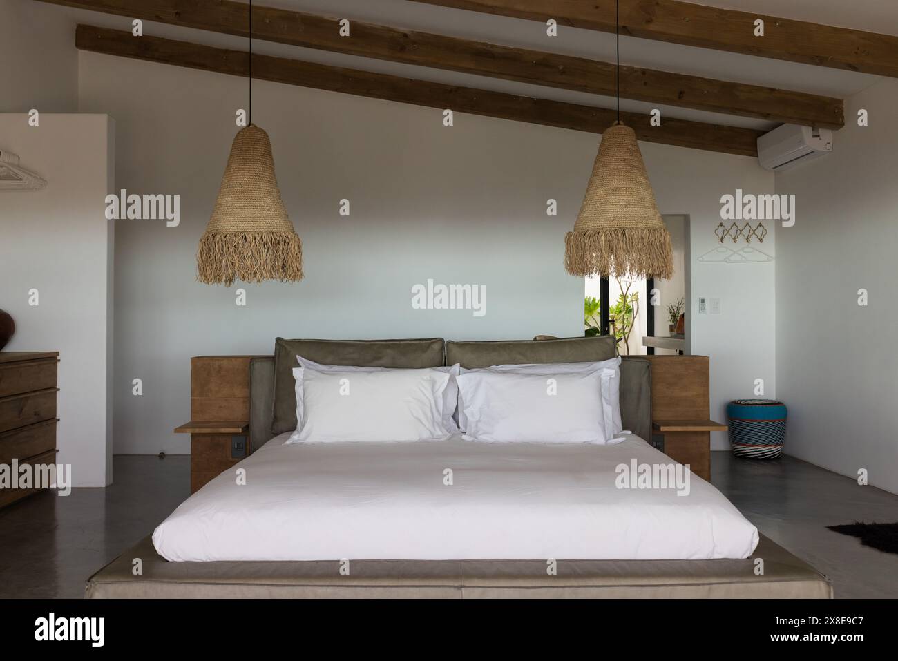 A casa, il letto grande domina la camera da letto minimalista Foto Stock