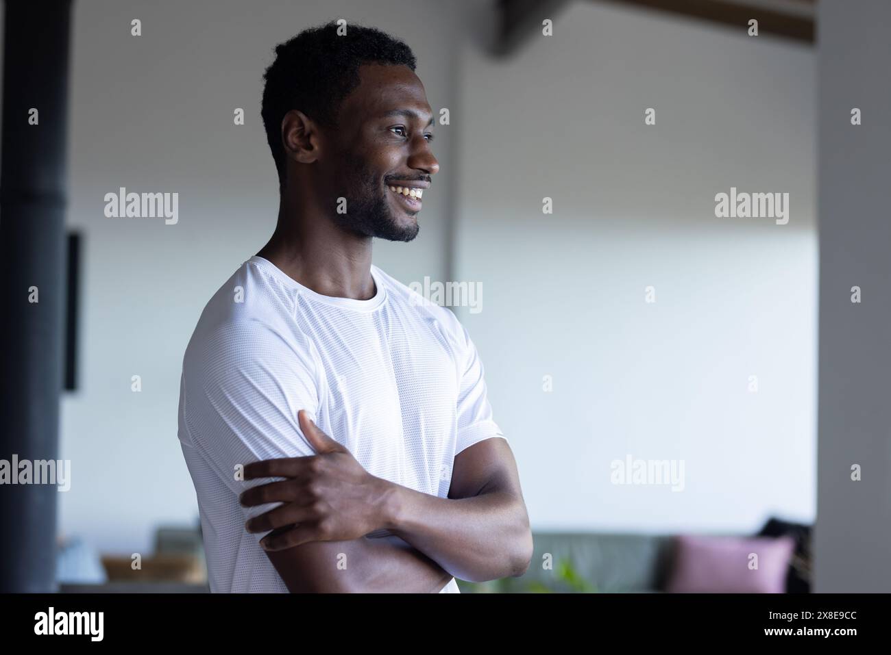 L'uomo afroamericano in camicia bianca sta a casa su sfondo blu Foto Stock