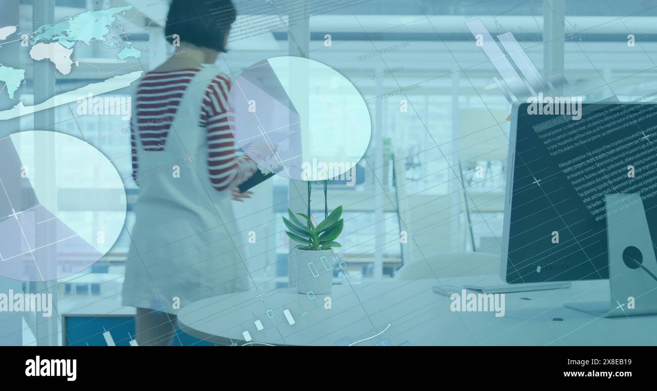 La donna birazziale a strisce visualizza i grafici dei dati su un grande schermo in un ufficio moderno Foto Stock
